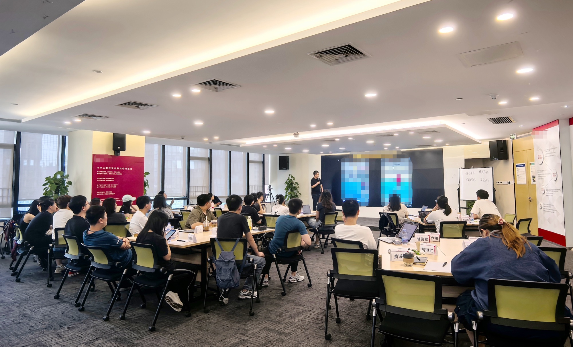 韩叙在线下课堂讲解业务，学员分组围桌学习