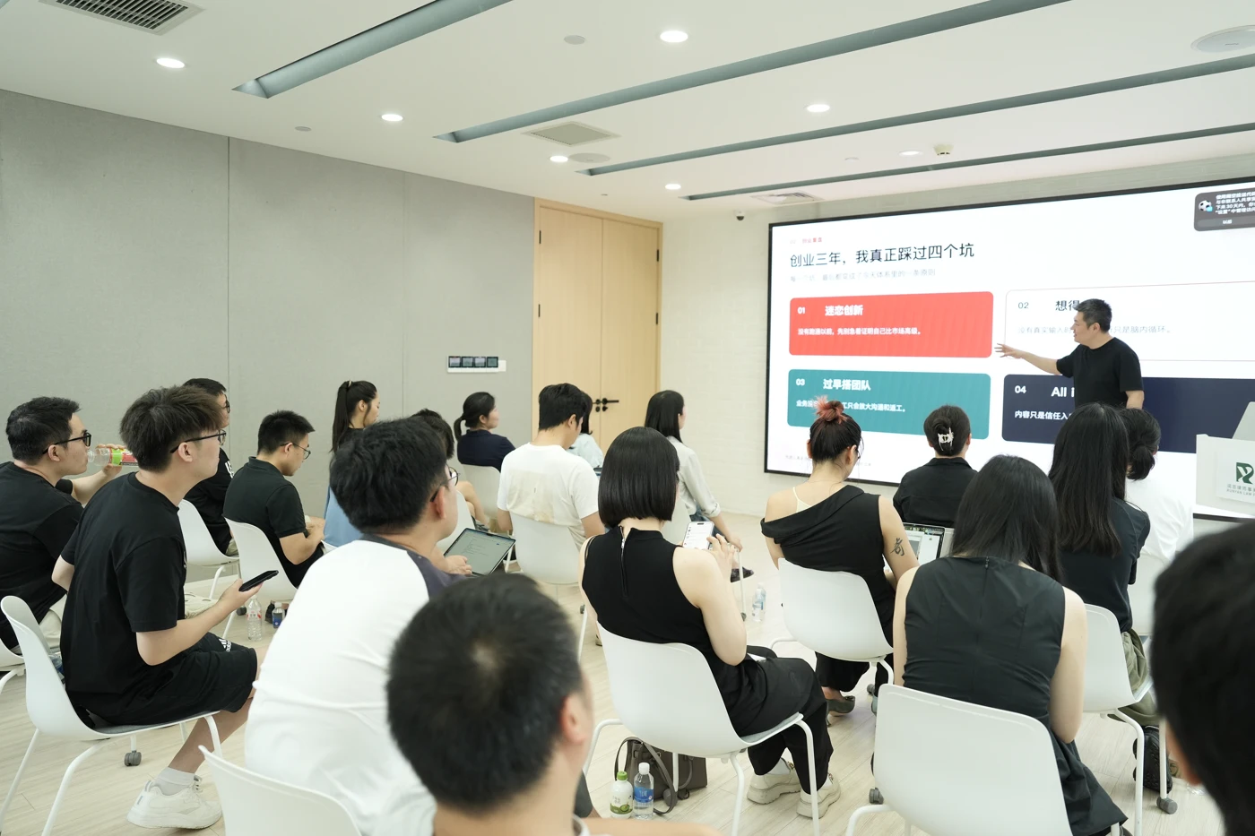 韩叙在屏幕前讲解,学员在课堂中听讲并记录